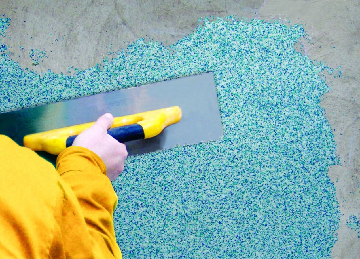 Barbat care aplica tencuiala mozaicata