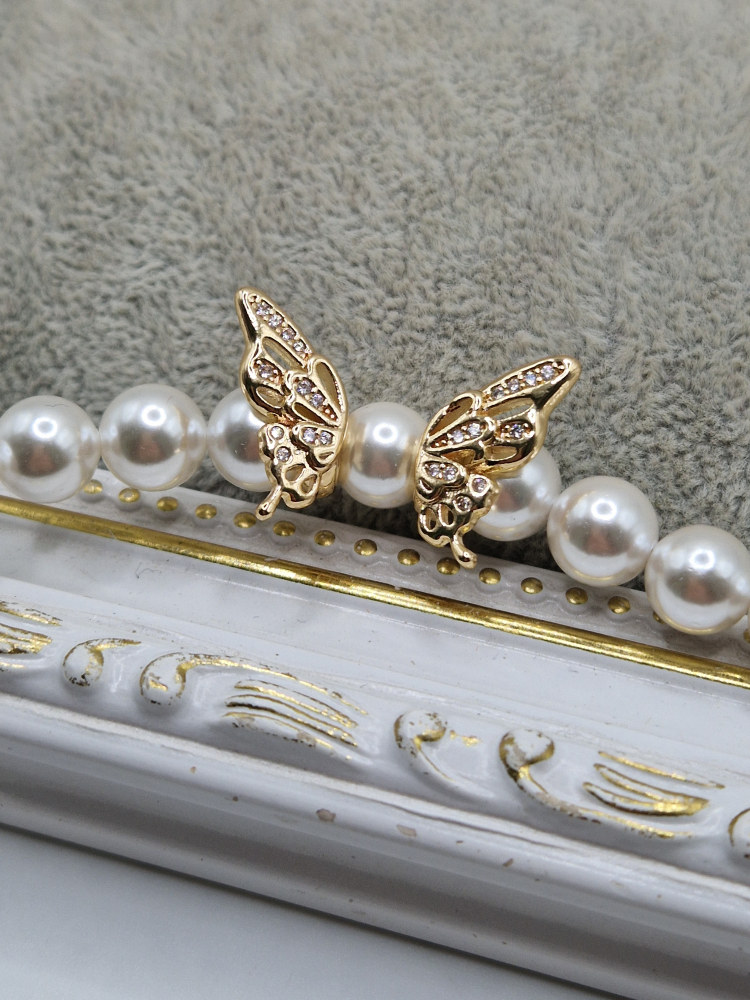 Colier realizat din Perle tip Mallorca albe si charm cubic zirconia sub forma de fluture. Inchidere din cupru placat cu aur 14k. [4]