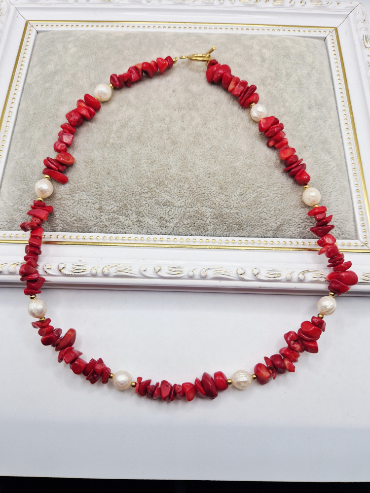 Colier realizat din Coral rosu chipsuri si Perle naturale sferice sculptate. Inchizatoarea este din otel inoxidabil auriu. [2]