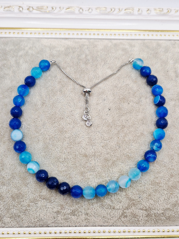 Set alcatuit din Colier realizat din Agate albastre si inchizatoare reglabila care se potriveste unui catel de talie mica si Bratara pe elastic asortata pentru stapana catelului. [2]