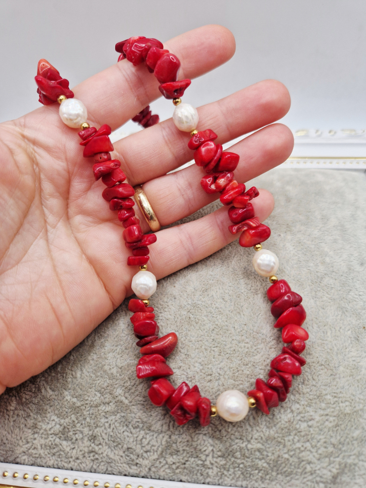 Colier realizat din Coral rosu chipsuri si Perle naturale sferice sculptate. Inchizatoarea este din otel inoxidabil auriu. [3]