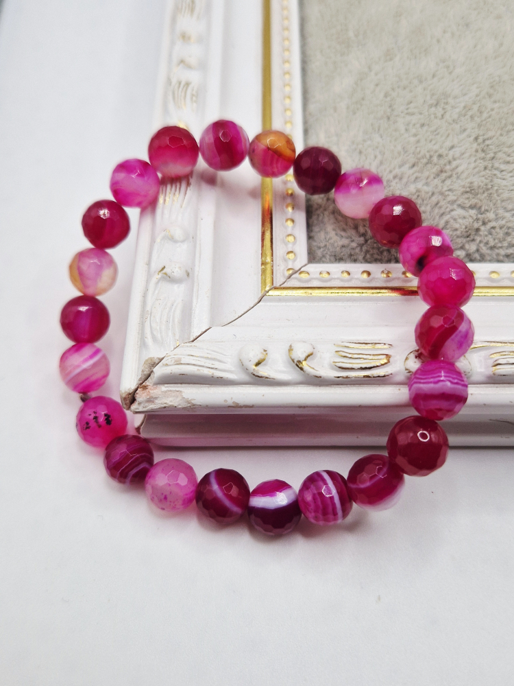 Set alcatuit din Colier realizat din Agate fucsia si inchizatoare reglabila care se potriveste unui catel de talie mica si Bratara pe elastic asortata pentru stapana catelului. [4]