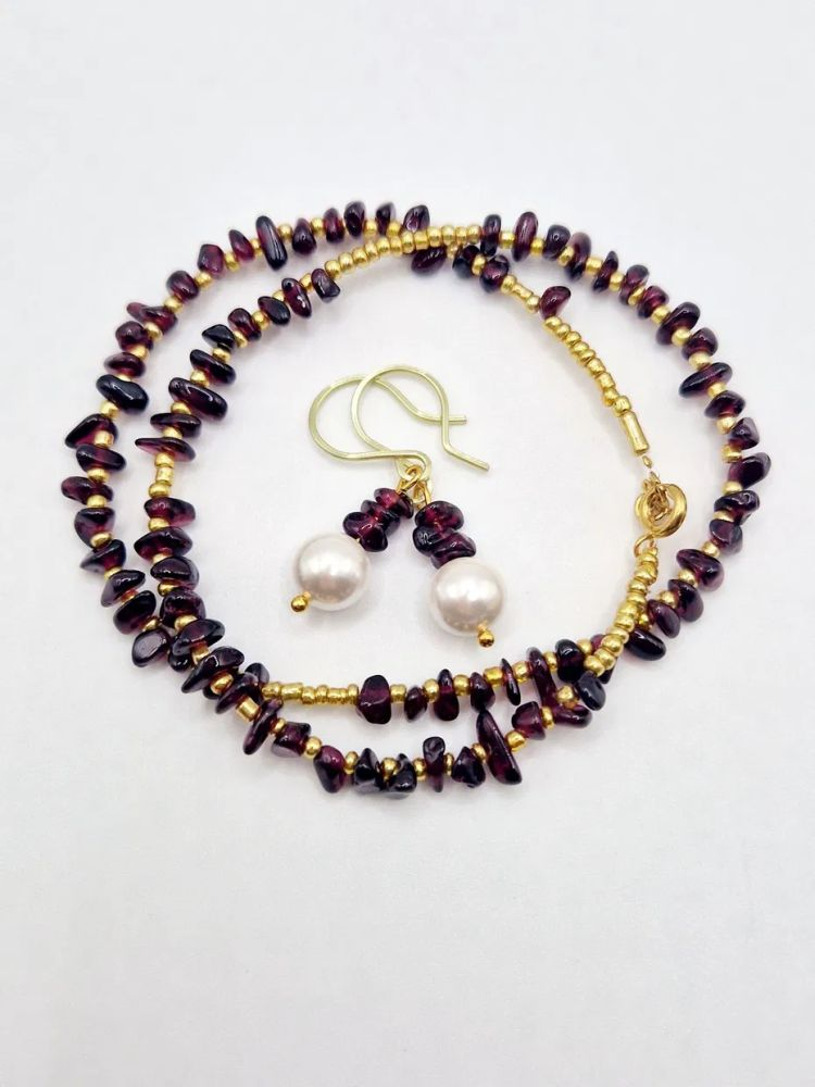 Setul este realizat din granat, forme neregulate și cercei cu perla Mallorca. [4]
