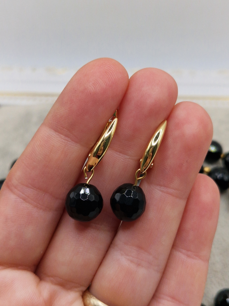 Set alcatuit din colier si cercei realizati din onix negru fatetat si sfere aurii din otel inoxidabil. Inchizatoare si tortite din cubic zirconia. [3]