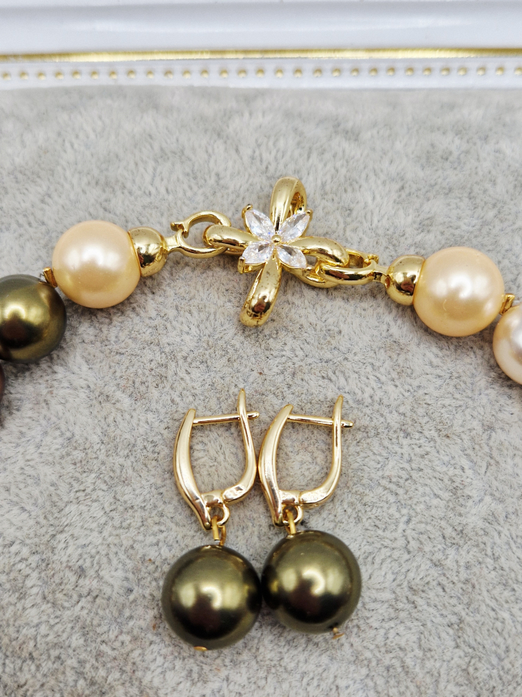 Set alcatuit din Colier si Cercei, realizat din Perle tip Mallorca multicolore (nuante de auriu, maro si kaki) si inchizatoare cubic zirconia. [2]