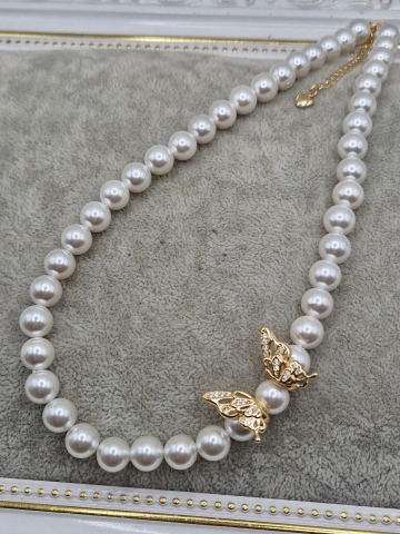 Colier realizat din Perle tip Mallorca albe si charm cubic zirconia sub forma de fluture. Inchidere din cupru placat cu aur 14k. [1]