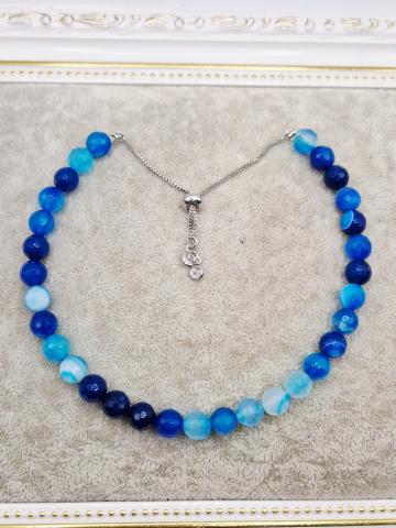 Set alcatuit din Colier realizat din Agate albastre si inchizatoare reglabila care se potriveste unui catel de talie mica si Bratara pe elastic asortata pentru stapana catelului. [1]