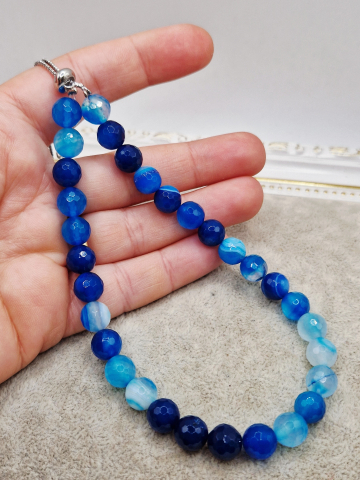 Set alcatuit din Colier realizat din Agate albastre si inchizatoare reglabila care se potriveste unui catel de talie mica si Bratara pe elastic asortata pentru stapana catelului. [2]