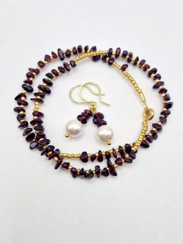 Setul este realizat din granat, forme neregulate și cercei cu perla Mallorca. [3]