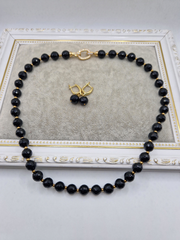 Seturi - Set alcatuit din colier si cercei realizati din onix negru fatetat si sfere aurii din otel inoxidabil. Inchizatoare si tortite din cubic zirconia.