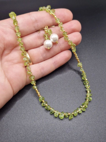 Setul este realizat din peridot, forme neregulate și cercei cu Perlă Mallorca. [2]