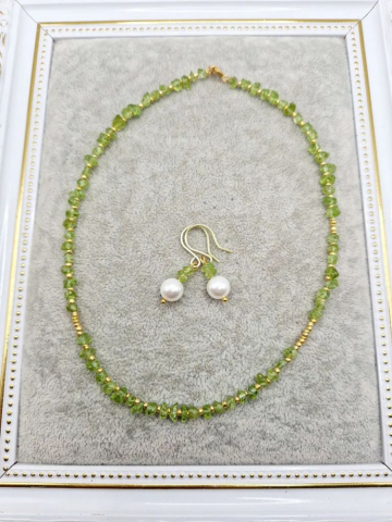 Setul este realizat din peridot, forme neregulate și cercei cu Perlă Mallorca. [4]