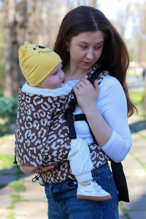 Luna UNA - Marsupiu ergonomic Luna Una de culoare neagra, purtat de un părinte cu bebeluș. Design ajustabil, bretele moi și glugă pentru susținerea capului.