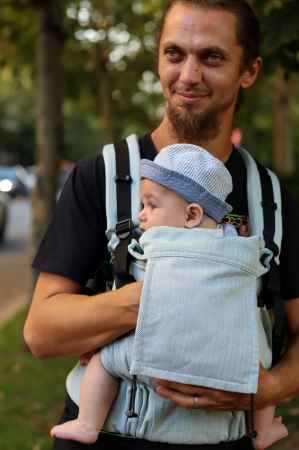 Luna UNA - Marsupiu ergonomic Luna Una de culoare neagra, purtat de un părinte cu bebeluș. Design ajustabil, bretele moi și glugă pentru susținerea capului.