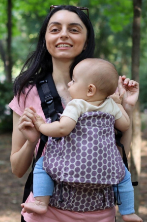 Luna UNA (0-36 Luni) - Marsupiu ergonomic Luna Una de culoare neagra, purtat de un părinte cu bebeluș. Design ajustabil, bretele moi și glugă pentru susținerea capului.