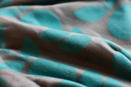 Marsupiu ergonomic Luna Una editie limitata, purtat de un părinte cu bebeluș. Design ajustabil, bretele moi și glugă pentru susținerea capului. [1]