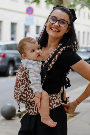Luna UNA - Marsupiu ergonomic Luna Una de culoare neagra, purtat de un părinte cu bebeluș. Design ajustabil, bretele moi și glugă pentru susținerea capului.