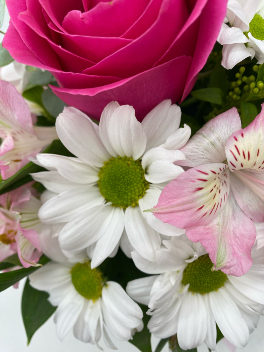 Aranjament floral ce conține trandafir, crizantema, ⁠alstroemeria și o cutie de Raffaello. [2]