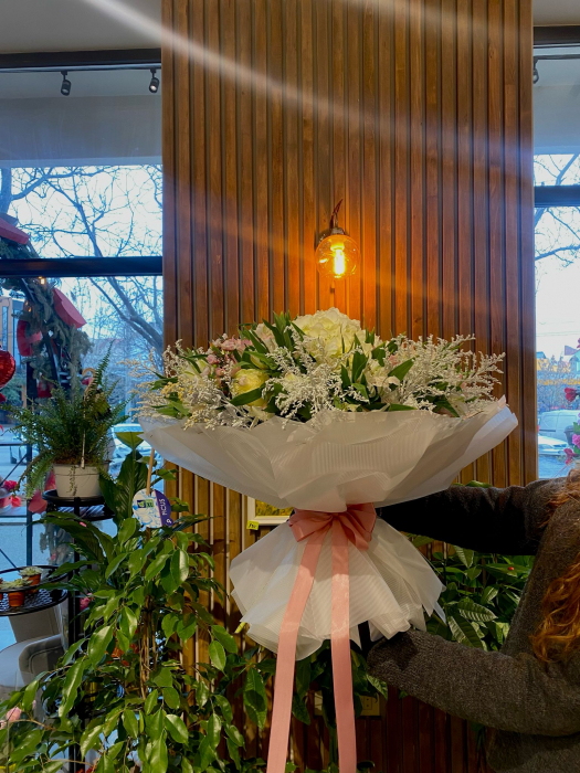 Buchetul conține hortensia, trandafiri albi, alstroemeria alb și roz, solidago alb și vax. [2]