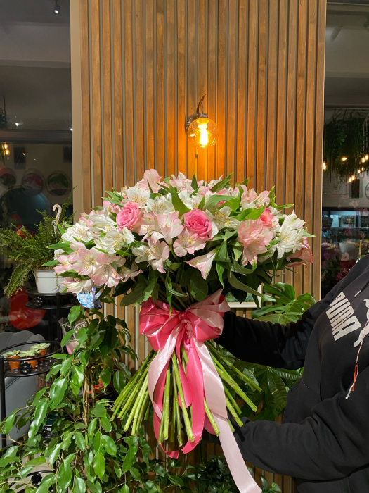 Buchetul conține trandafiri roz și alstroemeria alb/roz. [2]