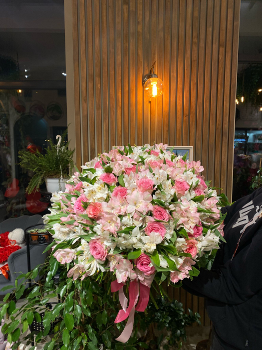 Buchetul conține trandafiri roz și alstroemeria alb/roz. [1]