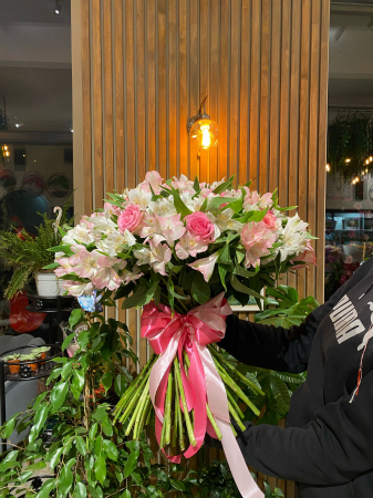Buchetul conține trandafiri roz și alstroemeria alb/roz. [1]