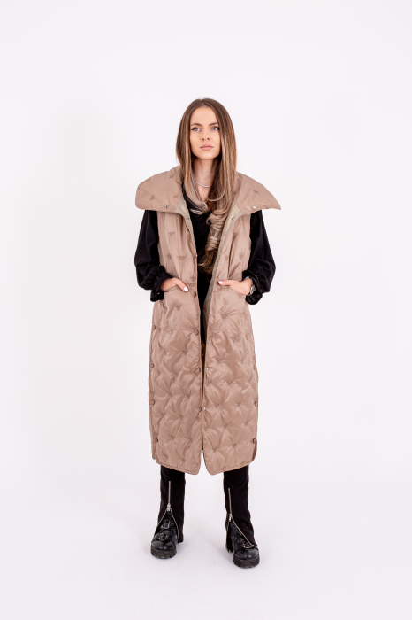 Vesta dama lungă cu capse laterale este o alegere stilată și practică pentru zilele reci. [1]