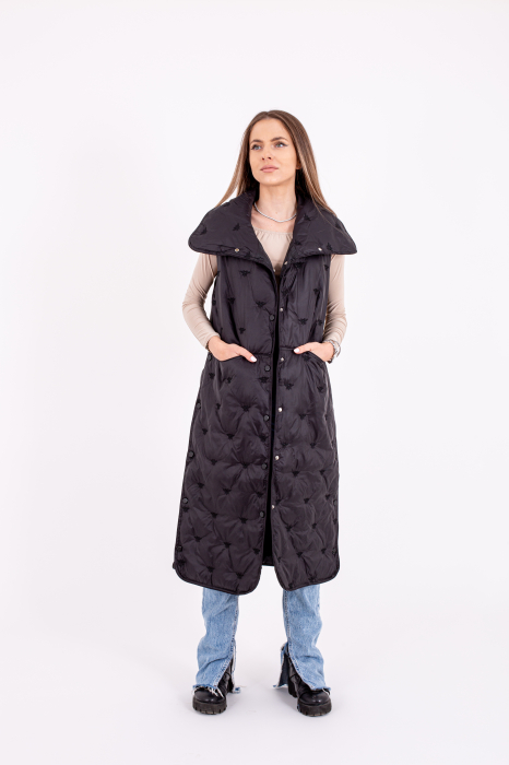Vesta dama lungă cu capse laterale este o alegere stilată și practică pentru zilele reci. [1]
