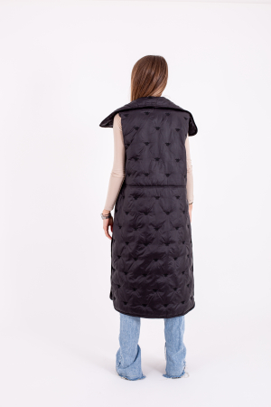 Vesta dama lungă cu capse laterale este o alegere stilată și practică pentru zilele reci. [1]