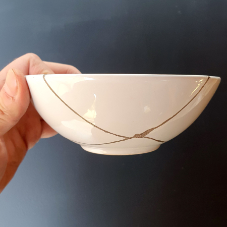 bol-kintsugi-argint-als002-1.jpg. Bol mic de porțelan alb, văzut din față, cu linii de argint în formă de X [1]