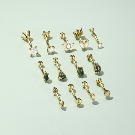 Cercei argint - Imaginea prezintă o colecție de bijuterii pentru piercing, mai exact modele de tip banană (curved barbell), realizate din argint placat cu aur galben și decorate cu diverse pietre.Aceste modele curbat