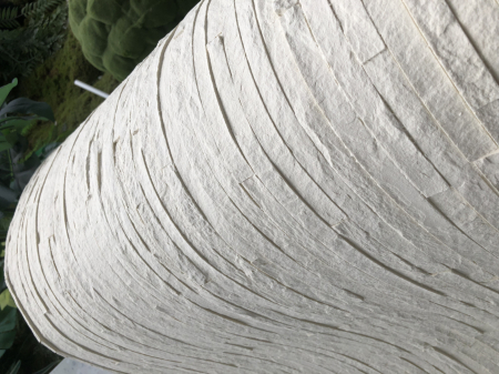 Panou din piatră flexibilă Slimstone ivoriu montat pe peretele unui living, textură de piatră în fâșii fine [6]