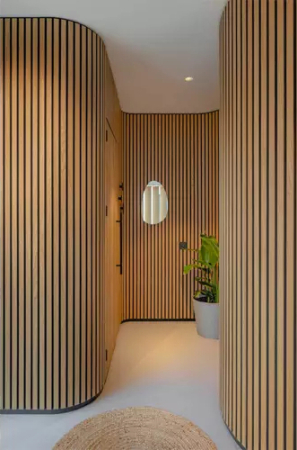 Riflaj acustic flexibil tec montat pe o coloană rotundă într-un living open-space [7]