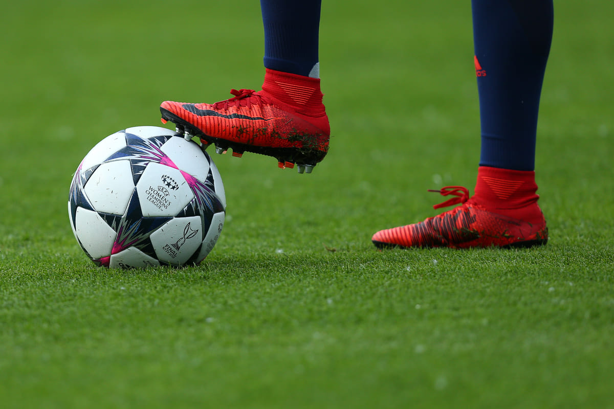 close up fotbalist pe iarba cu ghete fotbal Nike rosii si minge