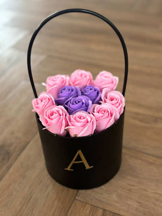Aranjament floral decorativ cu trandafiri roz și mov, în cutie neagră elegantă, personalizată cu inițiala numelui. [1]
