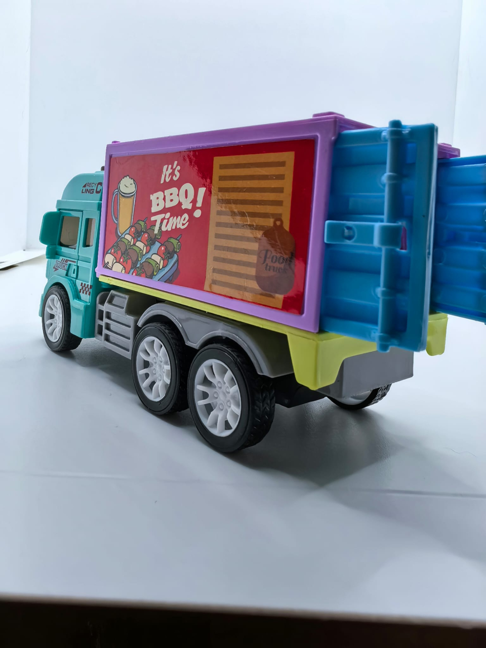 Mașinuță de jucărie tip food truck pentru înghețată, cu cabină roșie, dubă albastră și trapă spate deschisă. [3]