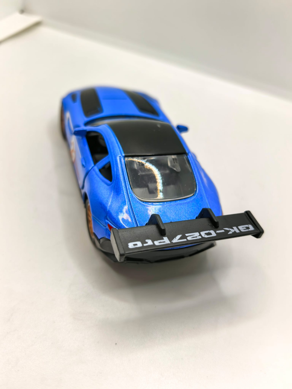 Machetă auto metalică sport de culoare roșie, cu ușa stângă deschisă, eleron și inscripția 21 Dream car. [4]