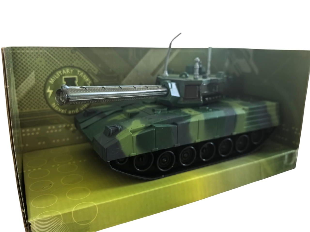 Tanc militar de jucărie cu model camuflaj deșert, țeavă lungă și antene, expus în cutia originală verde. [4]