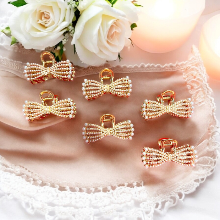 Clește de păr auriu în formă de fundiță decorat cu perle albe și cristale aurii. [2]