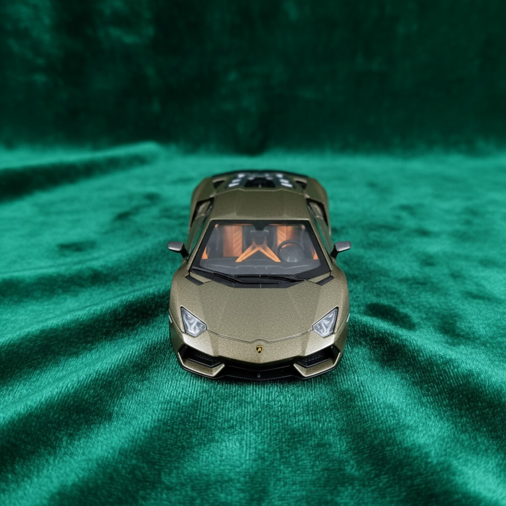 Machetă auto metalică Lamborghini Revuelto la scara 1:24, de culoare auriu mat, expusă pe un fundal din catifea verde [2]
