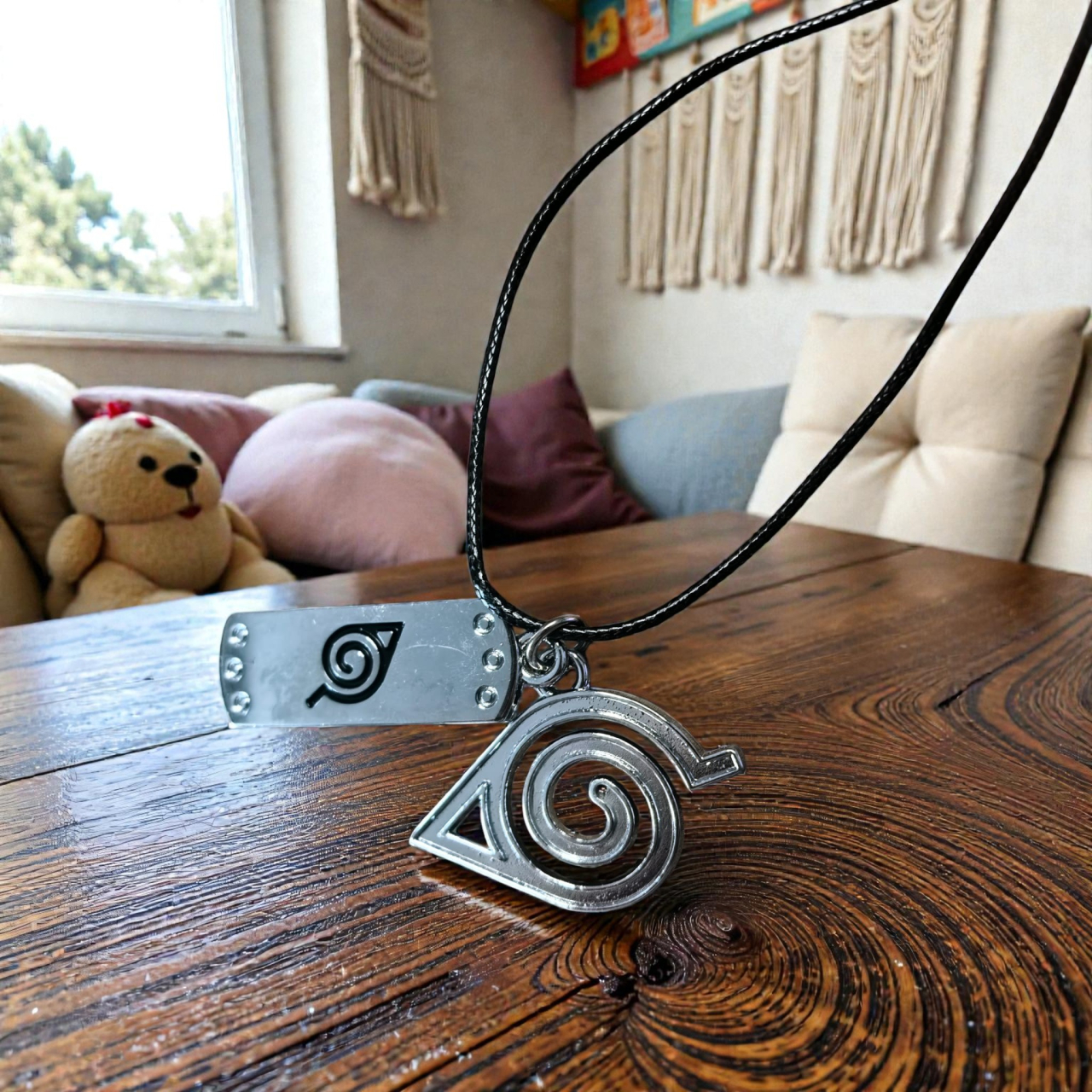 Set lănțișor de culoare neagră cu două pandantive argintii reprezentând simbolurile Konoha din seria Naruto. [2]