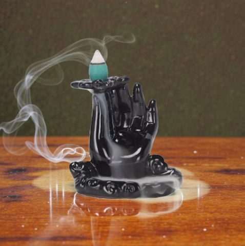 Fântâni Fum Pentru Conuri - Fântână de fum ceramică neagră model mână Mother Earth cu con aprins și cascadă de fum pe o suprafață de lemn.