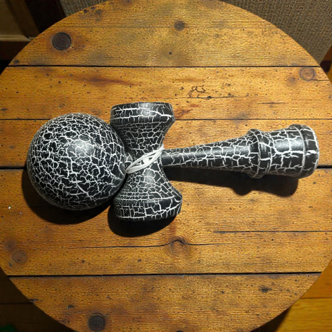 Kendama originală din lemn masiv cu finisaj crack effect roșu și negru, înălțime 18 cm.