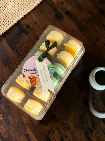 Delicii Parfumate: Lumânări Desert - Cutie transparentă cu 12 pastile din ceară de soia parfumată (wax melts) modelate sub formă de macarons galbene și verzi, decorată cu panglică și etichetă Handmade.