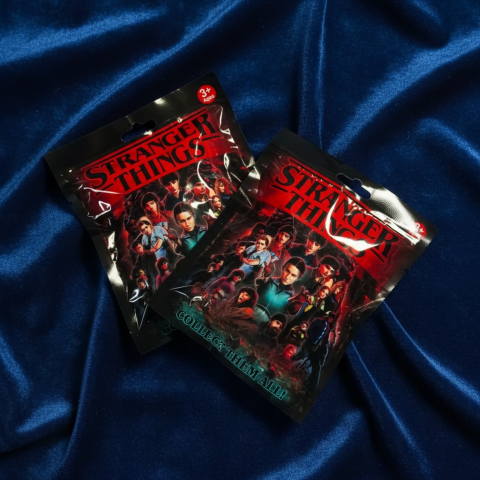 Jucării și Colecționabile Squid Game (Jocul Calamarului) - Plic individual mystery Stranger Things cu design colorat și sigilat, conținând o figurină surpriză.