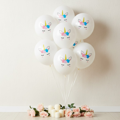 Baloane de poveste - Buchet de baloane albe din latex cu model față de unicorn și flori pastelate într-un decor luminos.