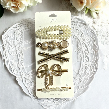 Clămițe colorate - Cartonaș cu 5 clame de păr elegante decorate cu perle albe și strasuri strălucitoare pe suport metalic auriu.