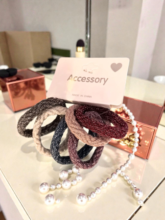 Clămițe colorate - Cartonaș cu 6 elastice de păr împletite cu fir sclipitor în nuanțe de roz, bordo și gri.