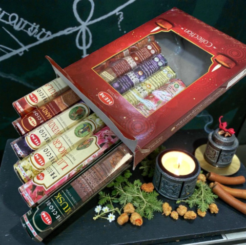 Bețișoare Parfumate - Cutie cadou roșie cu 6 variante de bețișoare parfumate HEM LOVE YOU Collection alături de o lumânare aprinsă.