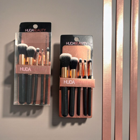 Pensule de Machiaj - Set 5 pensule de machiaj Rose Gold cu peri albi/gri, așezate pe un fundal estetic.